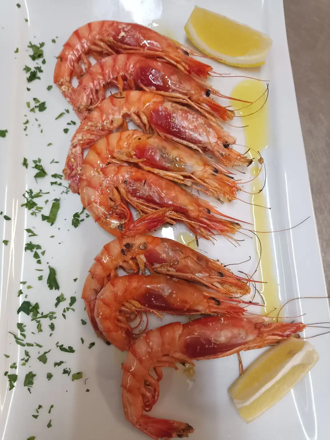 Gambas a la plancha en La Cullera del Poal, restaurante de cocina mediterránea en Vinaròs, servidas con limón y aceite de oliva.